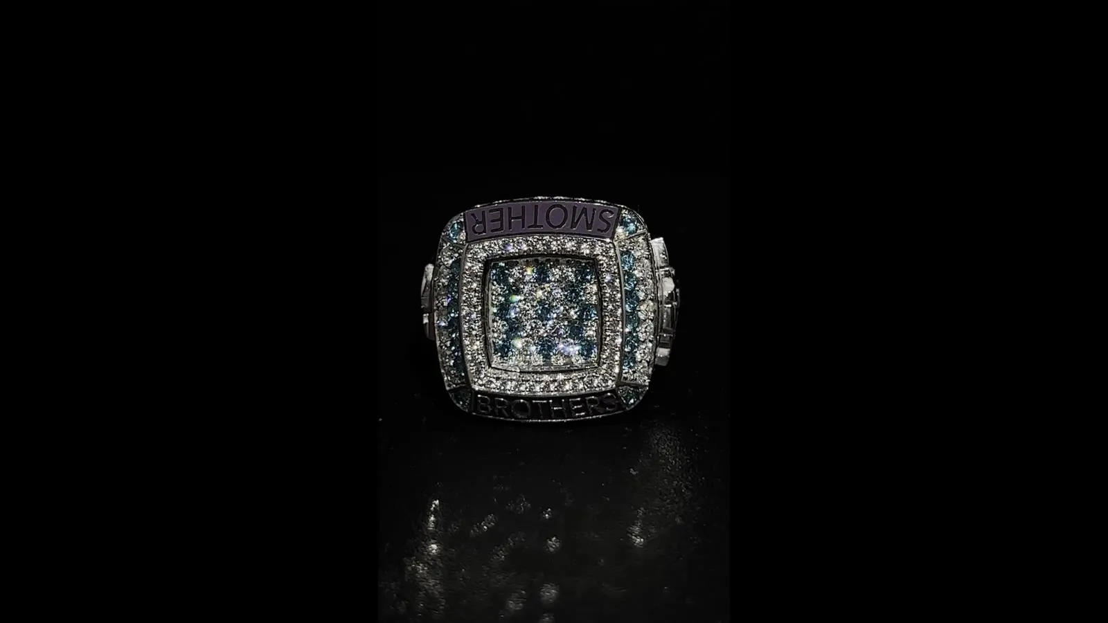 A square signet ring fully set with white diamonds and coloured stones